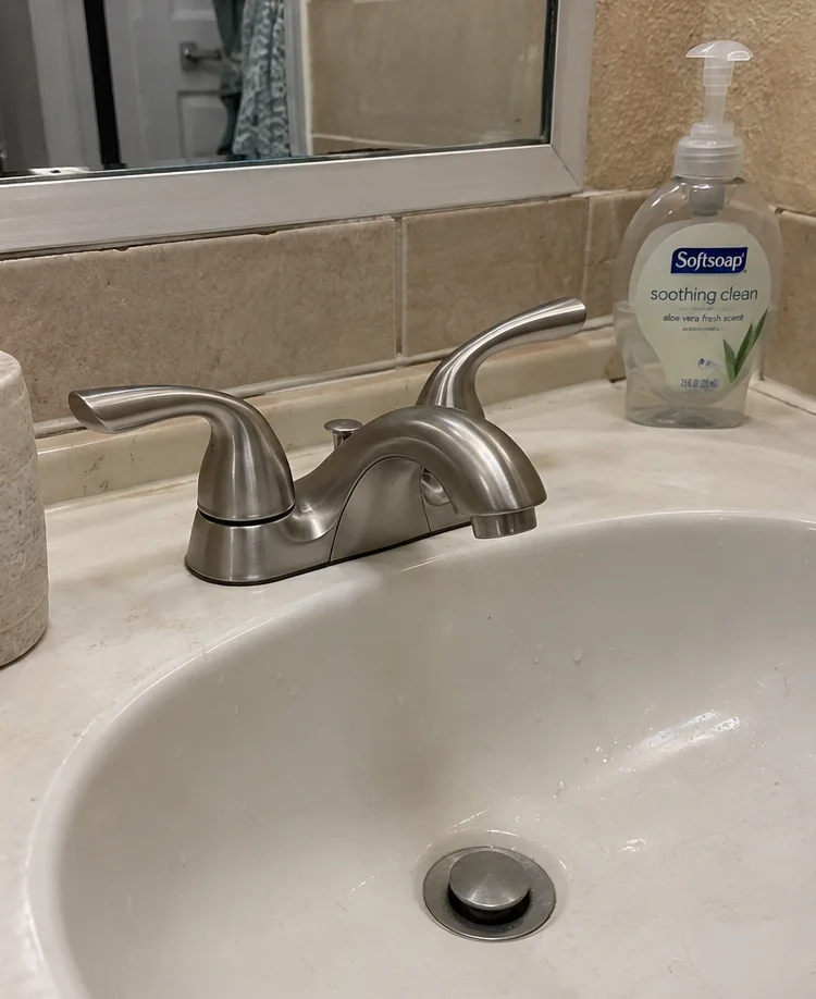 a new brushed-nickel two-handle faucet on the same sink
